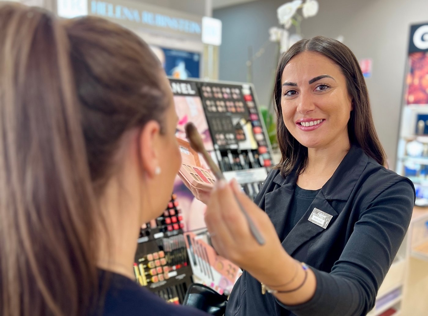 Woman applying makeup in a store.