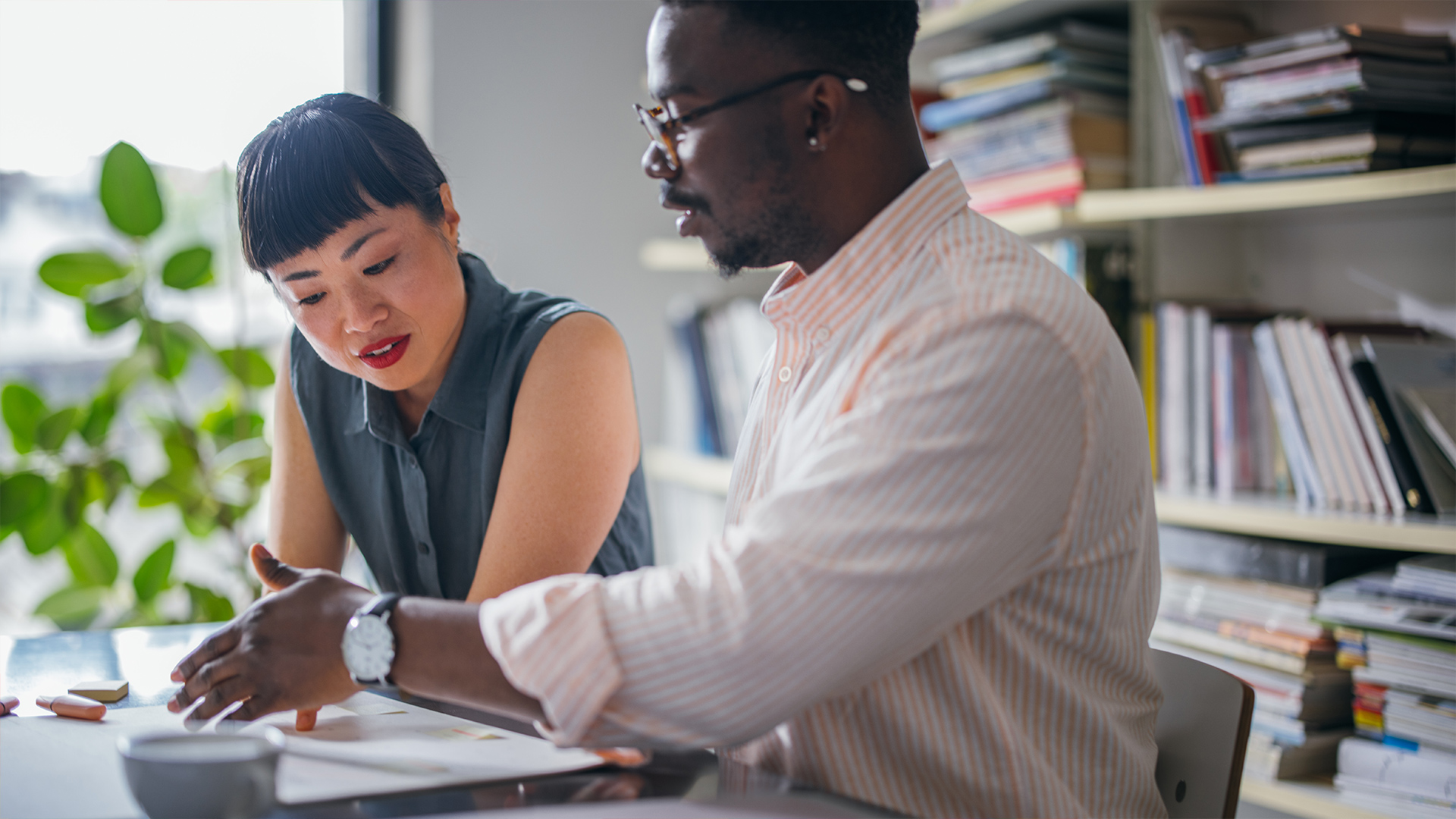People discussing and working together at a desk.