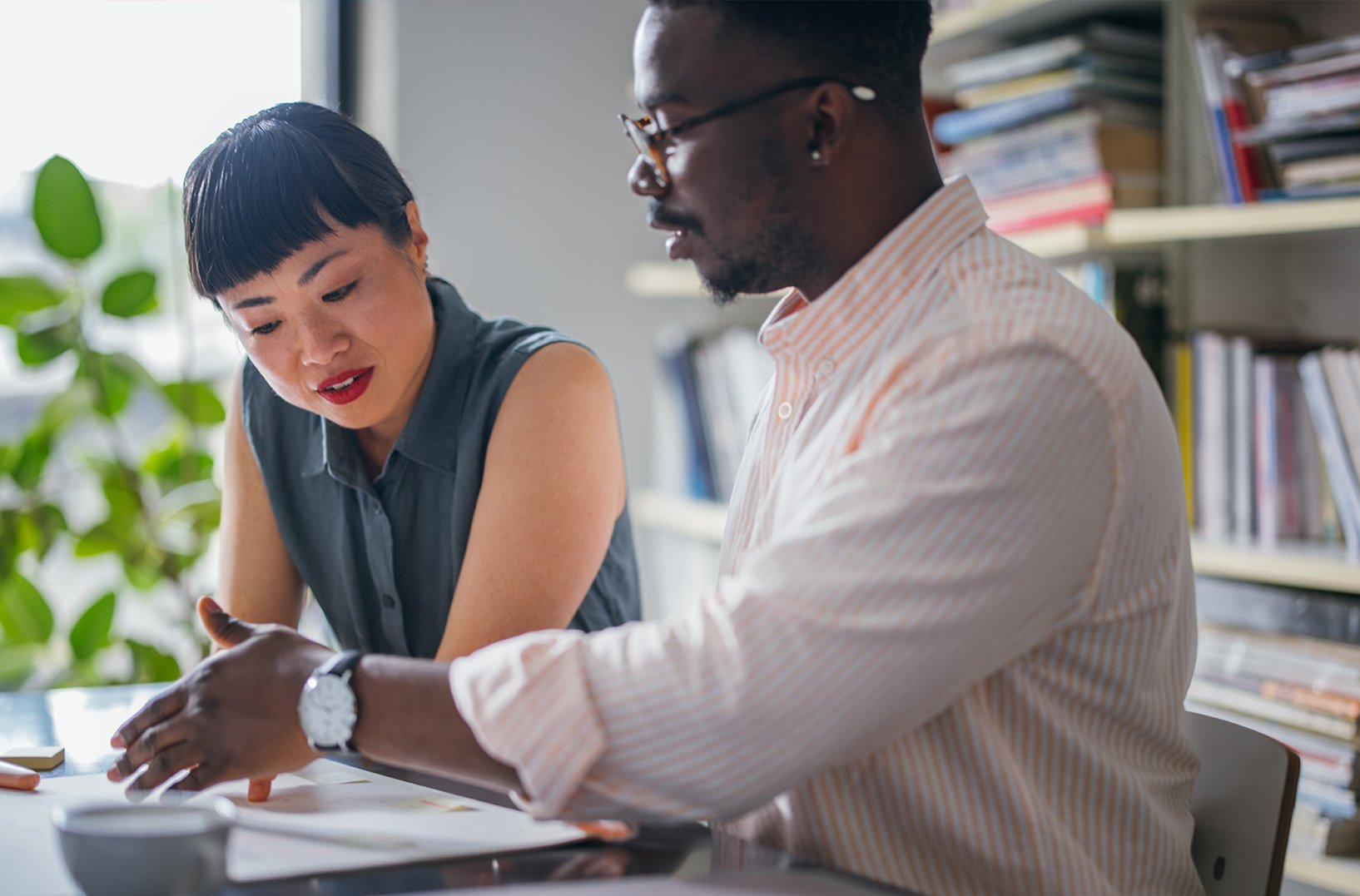 People discussing and working together at a desk.